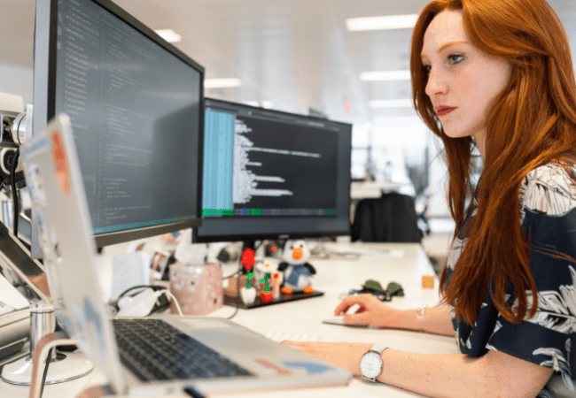jeune femme devant écran avec lignes de code