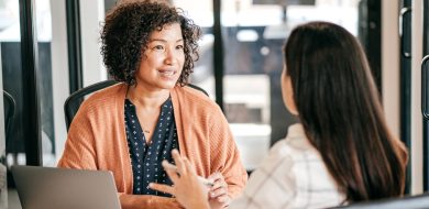 Femme pitch son projet professionnelle lors d'un entretien d'embauche avec une recruteuse dans un bureau lumineux