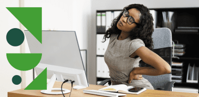 Femme assise à son bureau, manifestement inconfortable, se tenant le bas du dos pour soulager une douleur liée à une posture prolongée.