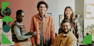 Quatre jeunes adultes souriants posent ensemble dans un espace de travail chaleureux et lumineux, symbolisant la bienveillance et la collaboration en formation professionnelle.