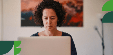 Femme concentrée travaillant sur un ordinateur portable, illustrant la réflexion nécessaire pour préparer une reconversion professionnelle.