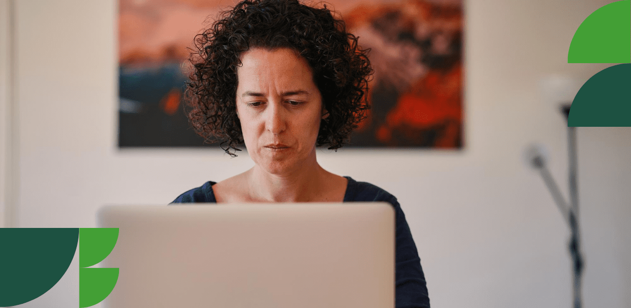 Femme concentrée travaillant sur un ordinateur portable, illustrant la réflexion nécessaire pour préparer une reconversion professionnelle.