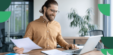 Adulte en reconversion travaillant sur des documents comptables et un ordinateur portable.
