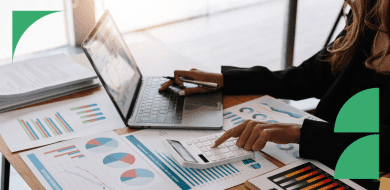 Professionnelle analysant des tableaux financiers sur ordinateur et calculatrice pour comprendre un bilan et un compte de résultat.